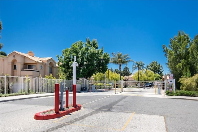 18818 Vista Del Canon Unit G, Newhall, CA 91321 - view of asphalt road with a gate, sidewalks, curbs, and a gated entry