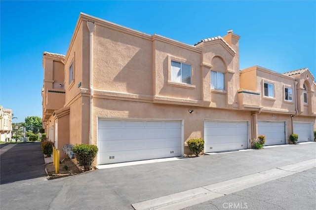18818 Vista Del Canon Unit G, Newhall, CA 91321 - multi unit property with stucco siding, an attached garage, a tile roof, and a chimney