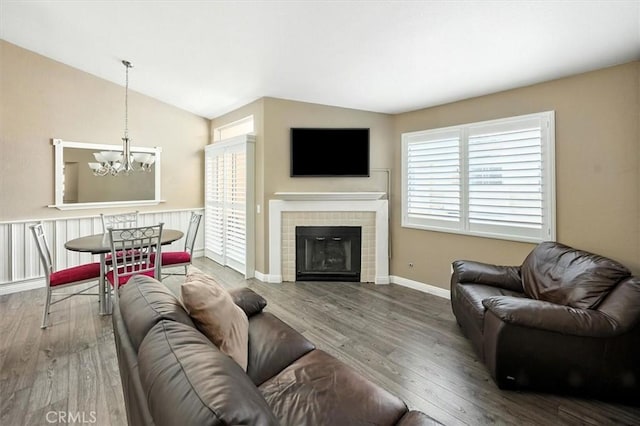 18818 Vista Del Canon Unit G, Newhall, CA 91321 - living area featuring a chandelier, wood finished floors, vaulted ceiling, and a tiled fireplace