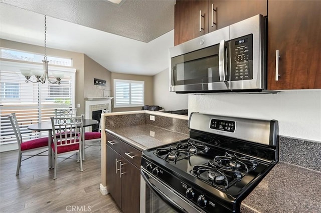 18818 Vista Del Canon Unit G, Newhall, CA 91321 - kitchen with appliances with stainless steel finishes, dark countertops, a chandelier, light wood finished floors, and lofted ceiling