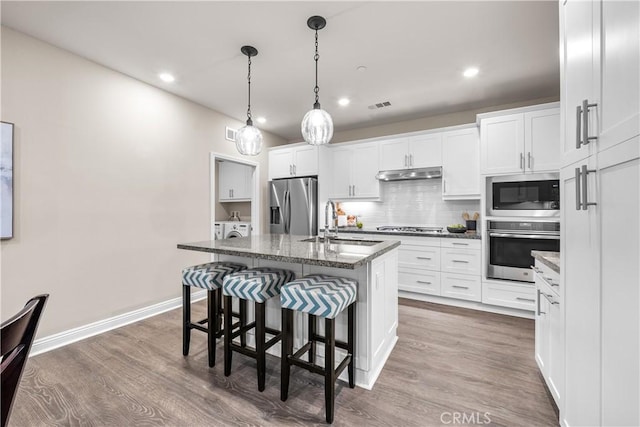 20552 Galloway, Saugus, CA 91350 - kitchen featuring stainless steel appliances, under cabinet range hood, white cabinetry, decorative backsplash, and recessed lighting