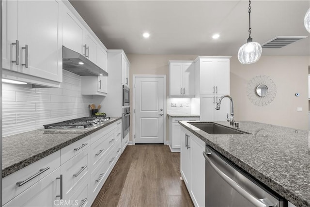 20552 Galloway, Saugus, CA 91350 - kitchen with under cabinet range hood, appliances with stainless steel finishes, white cabinets, dark wood finished floors, and decorative backsplash