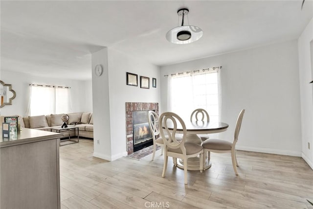 1029 S Reservoir St, Pomona, CA 91766 - dining space with a brick fireplace and light wood-type flooring
