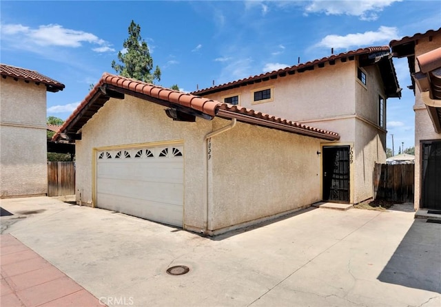 1029 S Reservoir St, Pomona, CA 91766 - mediterranean / spanish-style house featuring stucco siding, a tiled roof, and a garage
