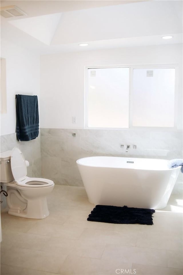 54889 Navajo Trl, Yucca Valley, CA 92284 - full bathroom featuring tile walls, a freestanding bath, tile patterned floors, and a wainscoted wall