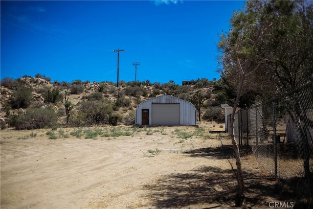 54889 Navajo Trl, Yucca Valley, CA 92284 - view of yard with a detached garage, an outdoor structure, and dirt driveway