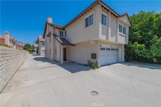 325 E Duarte Rd Unit C, Arcadia, CA 91006 - view of side of home featuring driveway, stucco siding, a garage, and a chimney