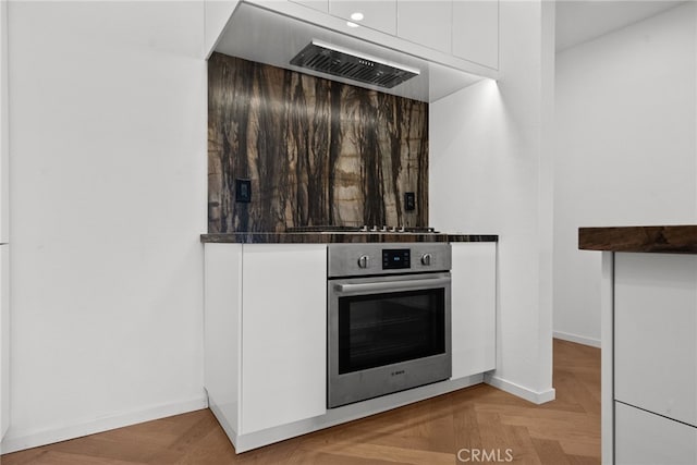 330 N Jackson St Unit 313, Glendale, CA 91206 - kitchen view of stainless steel oven, white cabinetry, dark countertops, and a bar