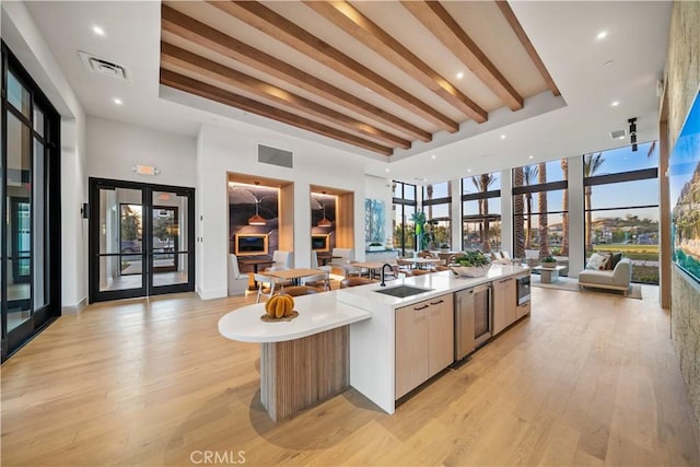 151 Fremont, Lake Forest, CA 92630 - kitchen featuring open floor plan, a large island, light wood-style flooring, light countertops, and a towering ceiling
