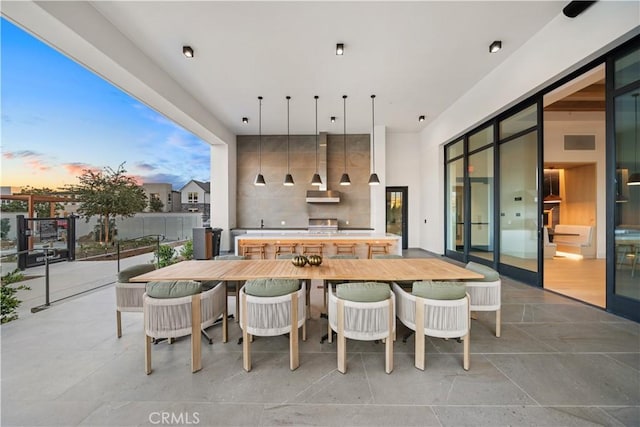 151 Fremont, Lake Forest, CA 92630 - patio terrace at dusk featuring outdoor dining space, an outdoor kitchen, and a patio area