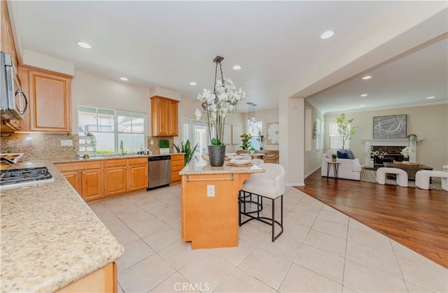 2142 Root St, Fullerton, CA 92833 - kitchen with stainless steel appliances, open floor plan, a kitchen island, a breakfast bar area, and decorative backsplash