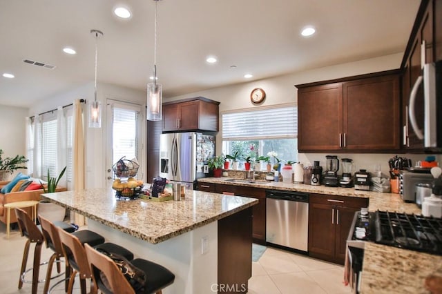 233 47th St, Long Beach, CA 90805 - kitchen with appliances with stainless steel finishes, light stone counters, recessed lighting, a kitchen island, and dark brown cabinets