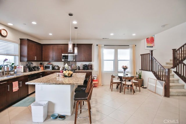 233 47th St, Long Beach, CA 90805 - kitchen featuring appliances with stainless steel finishes, plenty of natural light, dark brown cabinetry, light stone countertops, and recessed lighting
