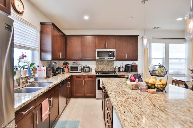 233 47th St, Long Beach, CA 90805 - kitchen featuring appliances with stainless steel finishes, plenty of natural light, light stone countertops, light tile patterned floors, and recessed lighting