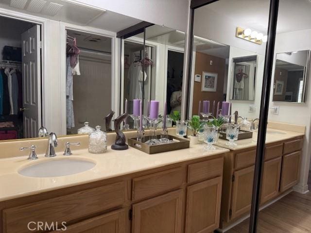 3211 Sello Ln Unit 100, Carlsbad, CA 92009 - full bathroom with double vanity, a spacious closet, and wood finished floors