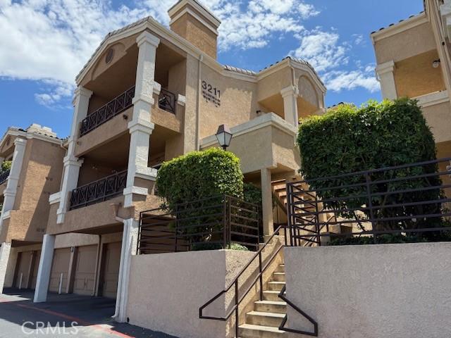 3211 Sello Ln Unit 100, Carlsbad, CA 92009 - view of building exterior with stairway and a garage