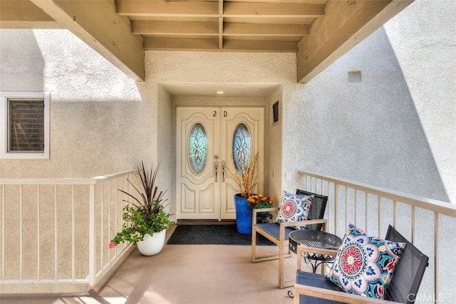 3242 San Amadeo Unit 2D, Laguna Woods, CA 92637 - doorway to property with stucco siding and a balcony