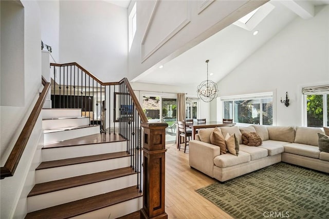 1205 Cerca, San Clemente, CA 92673 - staircase featuring high vaulted ceiling, wood finished floors, beam ceiling, a skylight, and a chandelier
