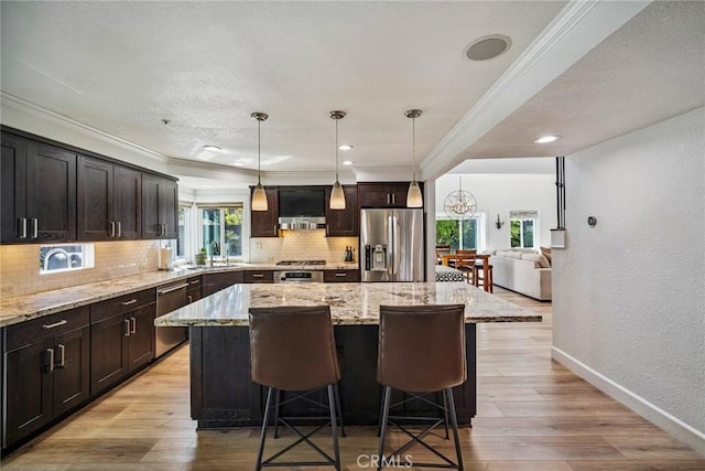 1205 Cerca, San Clemente, CA 92673 - kitchen with appliances with stainless steel finishes, ornamental molding, tasteful backsplash, a kitchen island, and a breakfast bar area
