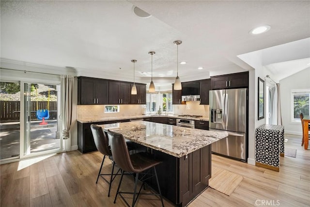 1205 Cerca, San Clemente, CA 92673 - kitchen featuring appliances with stainless steel finishes, light wood-style floors, light stone countertops, a kitchen island, and recessed lighting