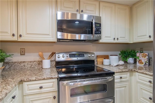 148 N Mine Canyon Rd Unit C, Orange, CA 92869 - kitchen featuring stainless steel appliances, cream cabinetry, and light stone countertops