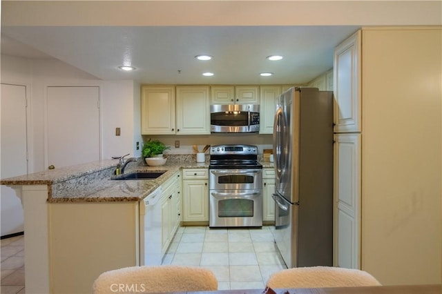148 N Mine Canyon Rd Unit C, Orange, CA 92869 - kitchen featuring appliances with stainless steel finishes, a peninsula, light tile patterned floors, light stone counters, and recessed lighting