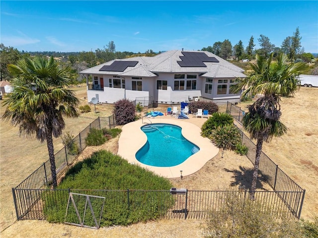 4620 Sandpiper Ln, Paradise, CA 95969 - rear view of house featuring roof mounted solar panels, a patio, a fenced backyard, stucco siding, and a tiled roof