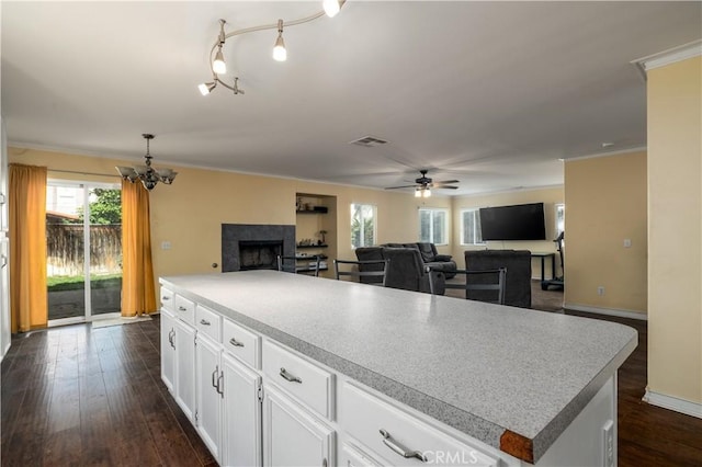 1649 Wrentree Way, Hemet, CA 92545 - kitchen with a tiled fireplace, ceiling fan, open floor plan, white cabinets, and a chandelier