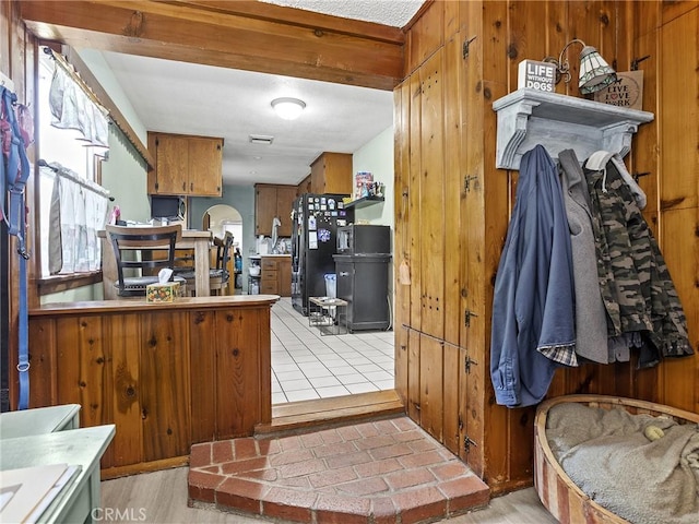 515 N Shelton St, Burbank, CA 91506 - kitchen featuring freestanding refrigerator, brown cabinetry, wooden walls, and tile counters