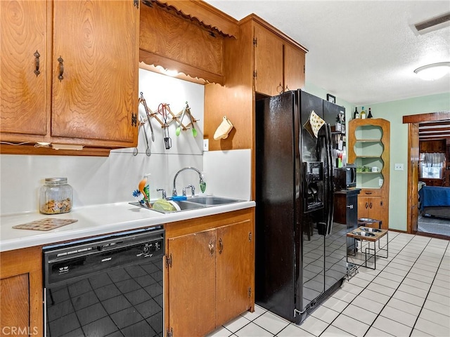 515 N Shelton St, Burbank, CA 91506 - kitchen featuring black appliances, light countertops, light tile patterned flooring, brown cabinets, and a textured ceiling