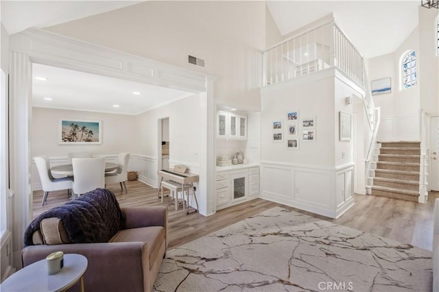 29282 Rue Cerise Unit 7, Laguna Niguel, CA 92677 - living area featuring light wood-type flooring, a decorative wall, wainscoting, ornamental molding, and stairway