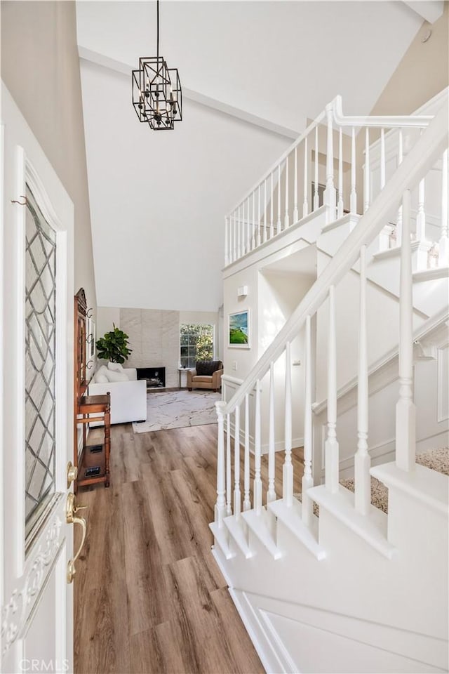 29282 Rue Cerise Unit 7, Laguna Niguel, CA 92677 - foyer with high vaulted ceiling, stairway, a high end fireplace, and wood finished floors