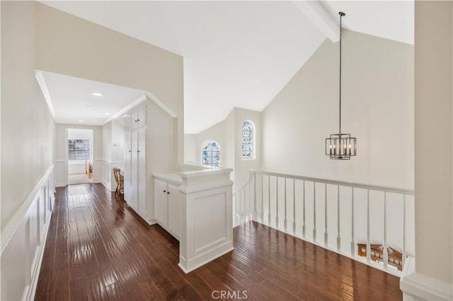29282 Rue Cerise Unit 7, Laguna Niguel, CA 92677 - corridor with dark wood-type flooring, an upstairs landing, beamed ceiling, a decorative wall, and a chandelier