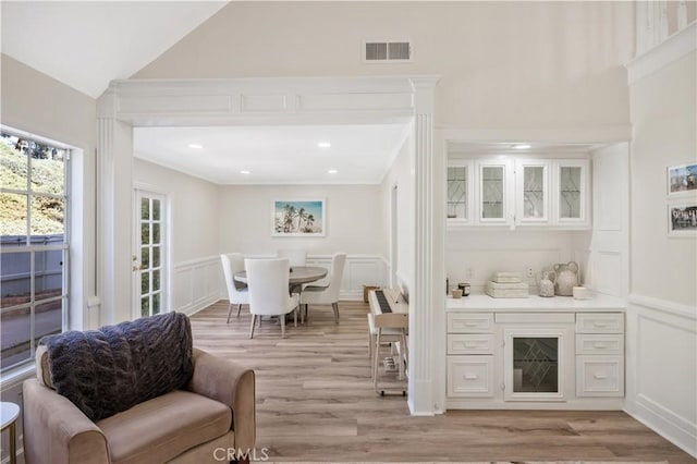 29282 Rue Cerise Unit 7, Laguna Niguel, CA 92677 - bar featuring a decorative wall, light wood finished floors, wainscoting, lofted ceiling, and crown molding