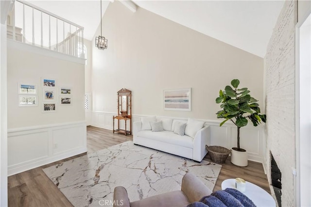 29282 Rue Cerise Unit 7, Laguna Niguel, CA 92677 - living area with wood finished floors, high vaulted ceiling, a wainscoted wall, and a decorative wall