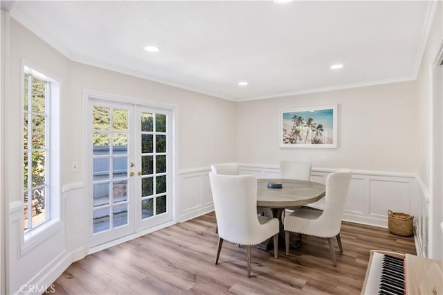 29282 Rue Cerise Unit 7, Laguna Niguel, CA 92677 - dining area with healthy amount of natural light, a decorative wall, crown molding, wood finished floors, and wainscoting