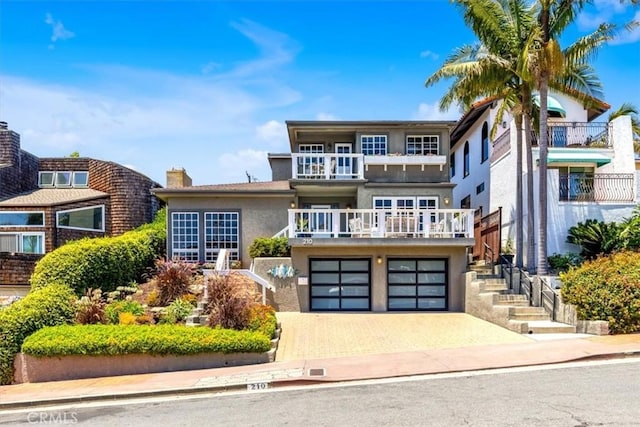 210 W Avenida Gaviota, San Clemente, CA 92672 - view of front of property with stucco siding, a balcony, driveway, an attached garage, and stairway