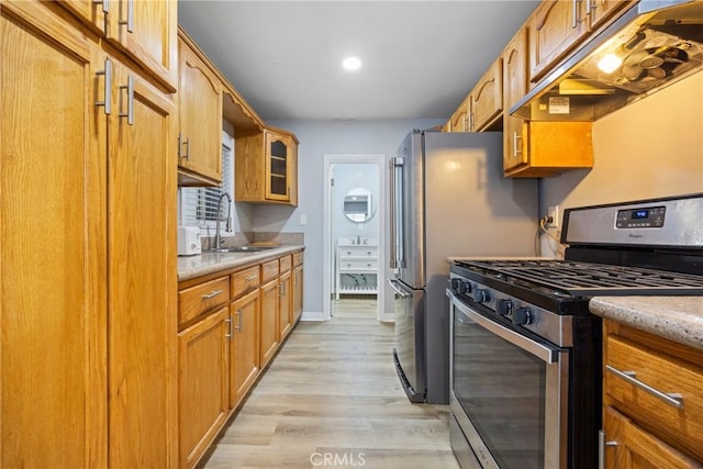 107 E Johnson St, Compton, CA 90220 - kitchen with stainless steel gas range oven, under cabinet range hood, glass insert cabinets, light wood finished floors, and brown cabinetry