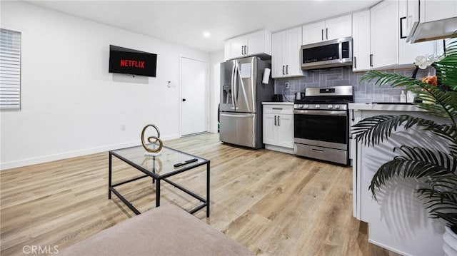 107 E Johnson St, Compton, CA 90220 - kitchen featuring appliances with stainless steel finishes, white cabinets, decorative backsplash, light wood finished floors, and recessed lighting