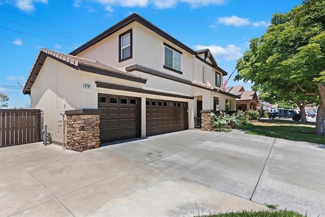 6701 Whitewater St, Eastvale, CA 91752 - view of home's exterior featuring stone siding, an attached garage, driveway, and stucco siding