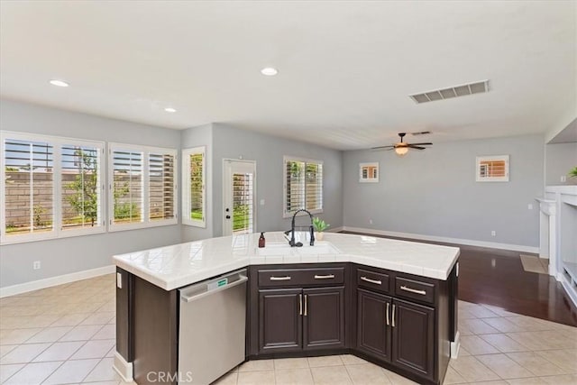 6701 Whitewater St, Eastvale, CA 91752 - kitchen with dishwasher, tile countertops, dark brown cabinetry, ceiling fan, and open floor plan