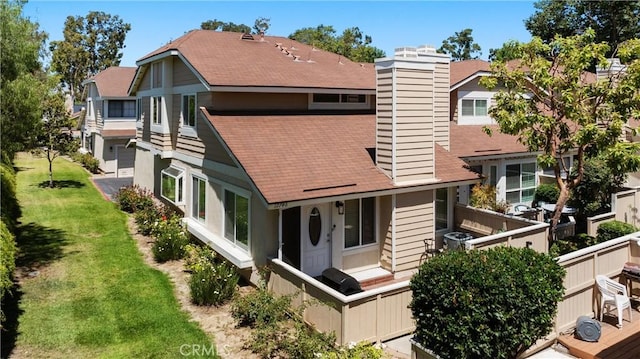 12746 Rosebrook Way, Stanton, CA 90680 - rear view of house with a chimney, a shingled roof, and a yard
