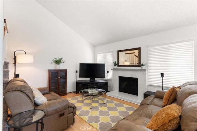 12746 Rosebrook Way, Stanton, CA 90680 - living area featuring lofted ceiling, light wood finished floors, a fireplace, and a textured ceiling