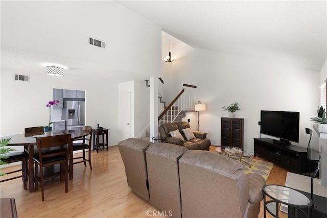 12746 Rosebrook Way, Stanton, CA 90680 - living room featuring light wood-style flooring, stairway, high vaulted ceiling, and a chandelier