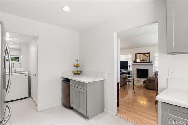 12746 Rosebrook Way, Stanton, CA 90680 - kitchen with gray cabinetry, a fireplace, light stone countertops, recessed lighting, and light tile patterned floors