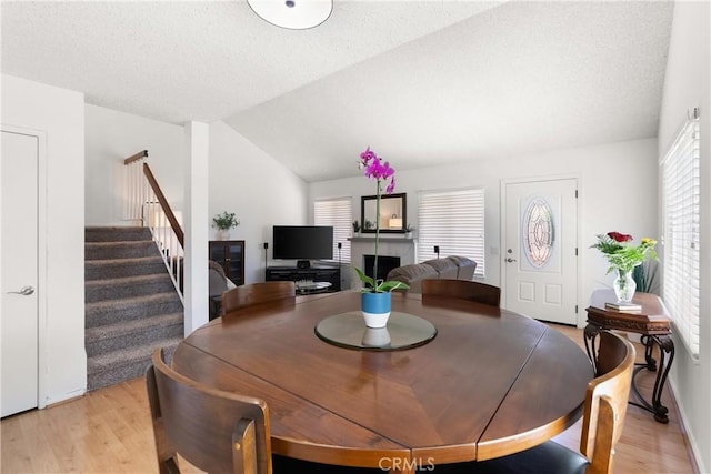 12746 Rosebrook Way, Stanton, CA 90680 - dining space with plenty of natural light, light wood-type flooring, stairway, vaulted ceiling, and a fireplace