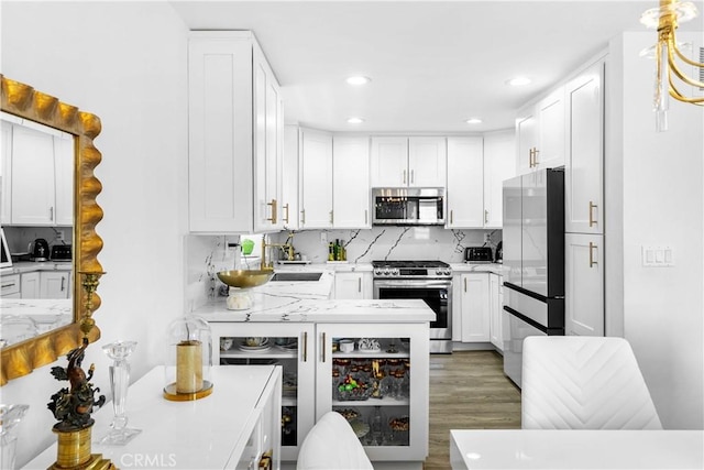 456 E San Jose Ave Unit C, Burbank, CA 91501 - kitchen featuring stainless steel appliances, tasteful backsplash, white cabinetry, recessed lighting, and wood finished floors