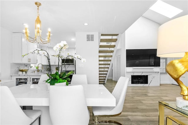 456 E San Jose Ave Unit C, Burbank, CA 91501 - dining space with a chandelier, stairs, light wood-style flooring, a fireplace, and recessed lighting