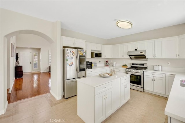 870 E Bermuda Dunes Ct, Ontario, CA 91761 - kitchen featuring stainless steel appliances, under cabinet range hood, arched walkways, light countertops, and a kitchen island