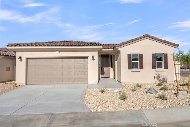 7444 Desert Sky Dr, Yucca Valley, CA 92284 - view of front of house featuring a garage, concrete driveway, stucco siding, and a tiled roof